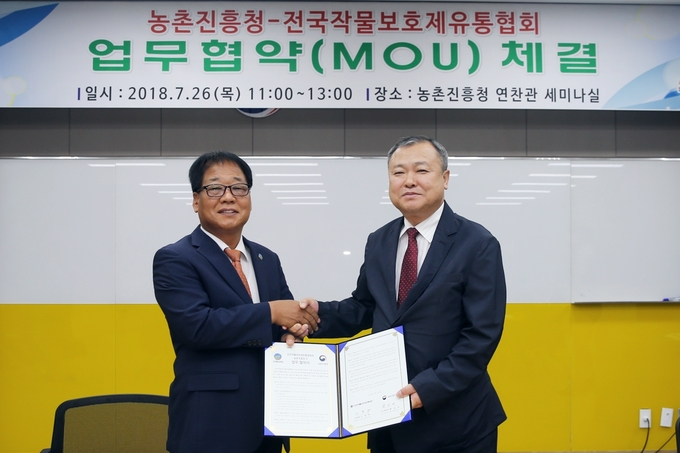농촌진흥청은 26일 올바른 농약 사용으로 안전한 먹거리를 생산할 수 있도록 지원하기 위해 전국작물보호제유통협회와 손을 잡았다. 이날 농촌진흥청 황규석 연구정책국장(왼쪽)과 전국작물보호제유통협회 신원택 회장은 국내 농업 발전과 농약의 안전관리, 농약허용물질목록관리제도(PLS) 정착 등에 협력한다는 내용을 담은 협약서에 서명한 뒤 기념 촬영을 하고 있다.<사진=농촌진흥청>