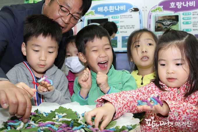 전북 전주의 농촌진흥청 농업과학관 1층에서 열린 ‘누에와 곤충 특별전시회’에서 농업생물부 이건휘 부장이 아이들에게 컬러누에를 소개했고,아이들은 직접 만져보고 즐거워 하고 있다.