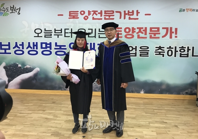 김철우 보성군수(오른쪽)가 제13기 보성생명농업대학 졸업식에서 우수교육생으로 선발된 김은진 씨에게 표창을 수여했다.